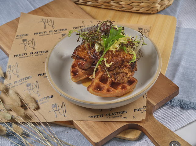 Hot Honey Chicken and Waffle — crispy fried chicken on a golden house waffle with hot honey drizzle and micro greens at Prettiplatters