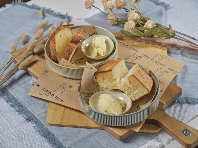 Warm sourdough house bread with whipped Vermont cultured butter served in ceramic bowls at Prettiplatters