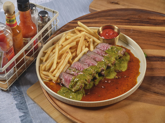 Steak Frites au Poivre — sliced NY steak with golden frites, chimichurri, and peppercorn sauce at Prettiplatters